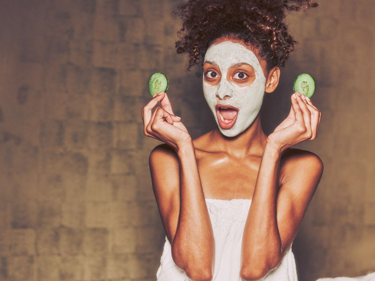 Woman holding cucumbers in her hands that she's just removed from her eyes after receiving a facial treatment at Viva Day Spa + Med Spa.